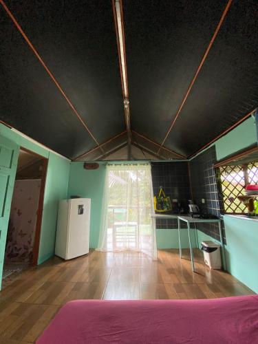 a room with a kitchen with a table and a refrigerator at Casita Tangara con balcón y agua caliente in Drake