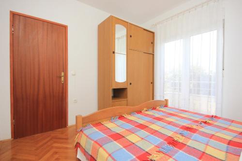 ノヴァリャにあるApartment Novalja 9326bのベッドルーム1室(ベッド1台、キャビネット、窓付)