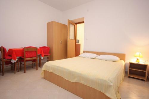 a bedroom with a bed and a table and chairs at Studio Zubovici 9365a in Zubovići