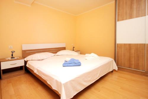 una camera da letto con un letto e un asciugamano blu di Seaside secluded apartments Cove Danca - Babina, Korcula - 9322 a Babina