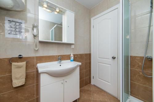 a bathroom with a sink and a shower and a mirror at Apartments by the sea Drvenik Donja vala, Makarska - 9654 in Drvenik