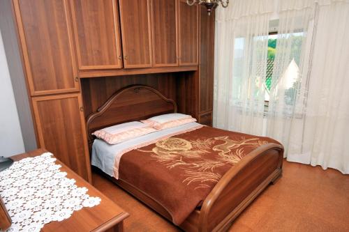1 dormitorio con 1 cama con cabecero de madera en Apartments with a parking space Lumbarda, Korcula - 9329, en Lumbarda