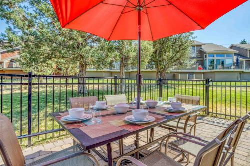 a patio table with a red umbrella and chairs at Aspen Retreat - Meredith Lodging in Redmond