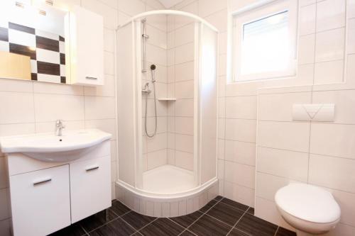 uma casa de banho branca com um chuveiro e um lavatório. em Apartment Duce 9437g em Dugi Rat