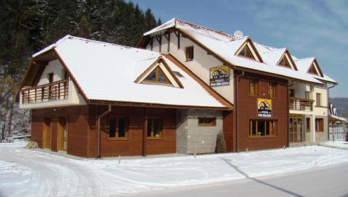 een groot huis met sneeuw op het dak bij Penzion pod Oblazom in Terchová