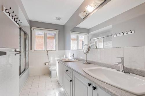 Baño blanco con lavabo y aseo en Luxurious Spacious Dream Home, en Richmond Hill