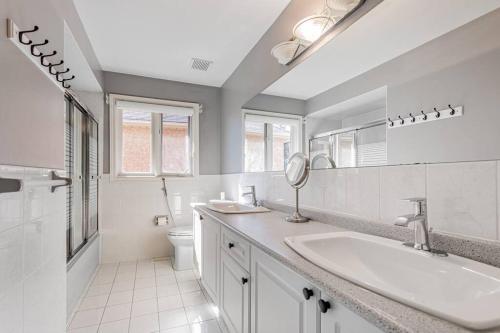 Un baño blanco con lavabo e inodoro. en Luxurious Spacious Dream Home, en Richmond Hill