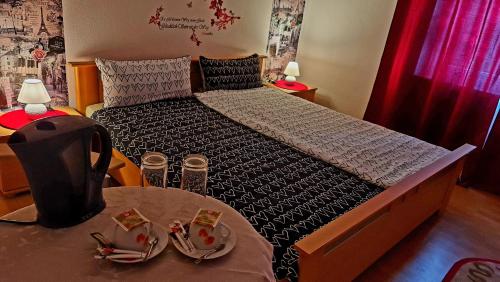 una piccola camera da letto con un letto e un tavolo con sidro. di Burger Station - Zimmervermietung a Immendingen