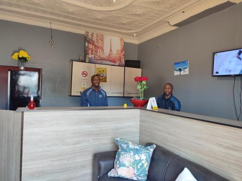 two men standing behind a counter at a bar at The Croc Guest house in Springs