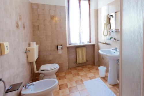 a bathroom with a toilet and a sink at Dogana Vecchia - Hotel & Residence B&B Ristorante & Pizzeria in Trivignano Udinese