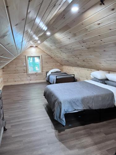 a bedroom with two beds in a wooden cabin at Camp Hudson Pines in Corinth