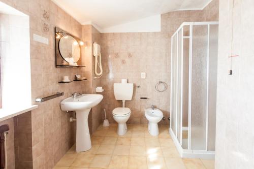 a bathroom with a toilet and a sink at Dogana Vecchia - Hotel & Residence B&B Ristorante & Pizzeria in Trivignano Udinese