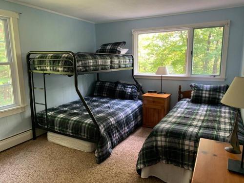 a bedroom with two bunk beds and a desk at Dog friendly Chalet in the Woods w/Pool-Mt. Snow in Wilmington