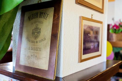 a wooden table with two framed photographs on it at Dogana Vecchia - Hotel & Residence B&B Ristorante & Pizzeria in Trivignano Udinese