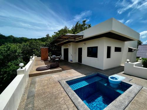 a villa with a swimming pool in front of a house at KohTao Studios Sunset in Ko Tao