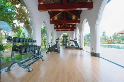 a gym with chairs and a pool in a building at Cantho Eco Resort in Can Tho