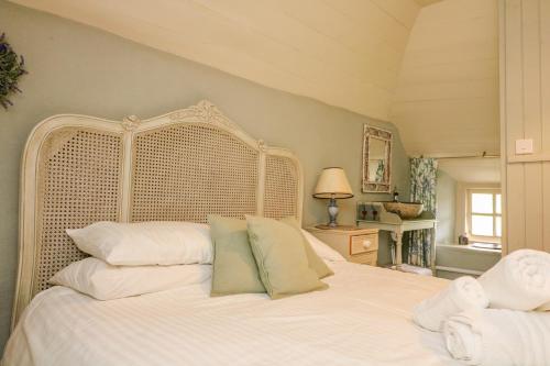 ein Schlafzimmer mit einem großen weißen Bett mit weißen Kissen in der Unterkunft Elworthy Cottage in Salcombe