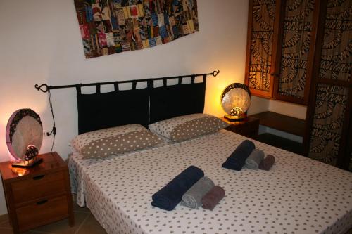 een slaapkamer met een bed met twee paar slippers erop bij Casa Bahia 6 in Santa Maria