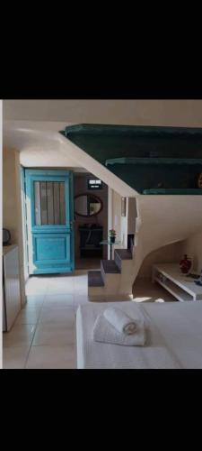 una camera con un letto e una porta e scale blu di Kritikies apollonia a Pitsidia