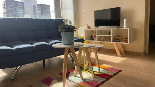 a living room with a blue couch and a table at Departamento Chillan céntrico in Chillán