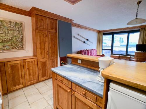 une cuisine avec des armoires en bois et un comptoir dans l'établissement Appartement spacieux pour 9 pers. à Tignes Val Claret, proche pistes et commerces, balcon sud - FR-1-502-387, à Tignes