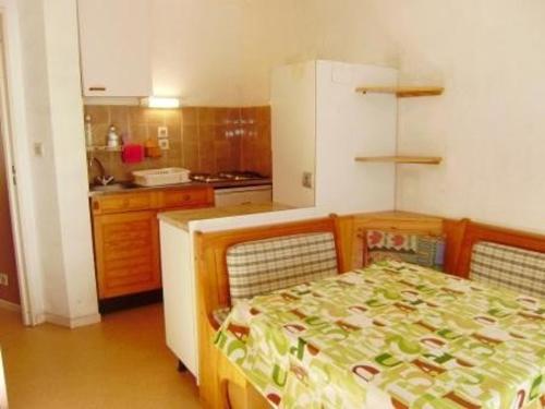une petite cuisine avec une table et un réfrigérateur dans l'établissement Studio cabine 2 pers avec parking à Esquièze-Sère - FR-1-402-124, à Esquièze - Sère