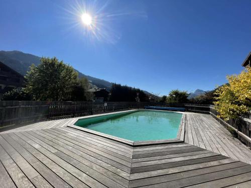 une piscine sur une terrasse en bois avec le soleil au-dessus dans l'établissement Studio Cabine Praz-sur-Arly - 4 pers, Terrasse, Piscine, Parking, Proche village et pistes - FR-1-603-63, à Praz-sur-Arly