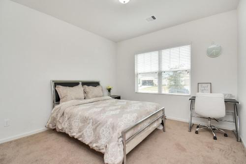 a white bedroom with a bed and a desk and a chair at CHARMING 4 BEDROOMS BROOKSHIRE/KATY WITH GYM in Brookshire