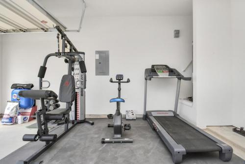 a gym with two tread machines and a treadmill at CHARMING 4 BEDROOMS BROOKSHIRE/KATY WITH GYM in Brookshire