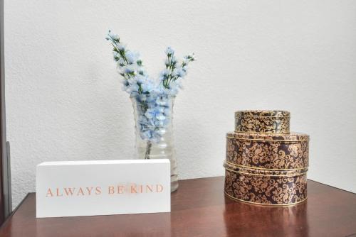 a table with a vase of flowers and a sign that says always be kind at CHARMING 4 BEDROOMS BROOKSHIRE/KATY WITH GYM in Brookshire