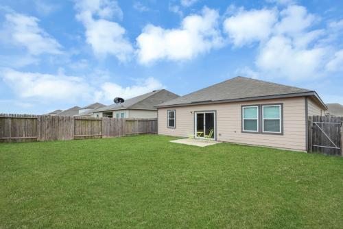 a house with a fence and a yard at CHARMING 4 BEDROOMS BROOKSHIRE/KATY WITH GYM in Brookshire