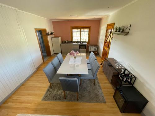a dining room with a table and chairs and a kitchen at Casa Vita BG - Casa de campo in Bento Gonçalves