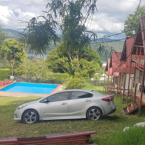 a silver car parked next to a house at Cabaña 8 Personas Lago Calima in Darién