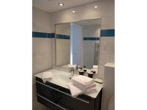 une salle de bain avec un lavabo et un miroir dans l'établissement Le Panoramer Sea View, à Cannes