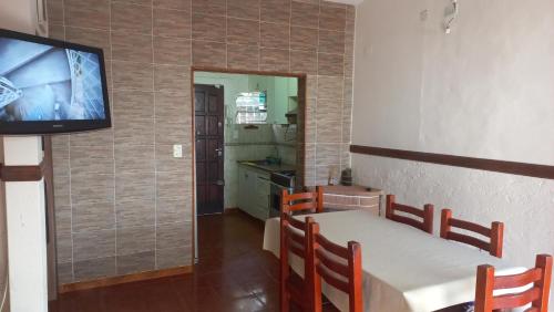 ein Esszimmer mit einem Tisch und einem Flachbild-TV in der Unterkunft Chalet " La Maruca " in Villa Carlos Paz
