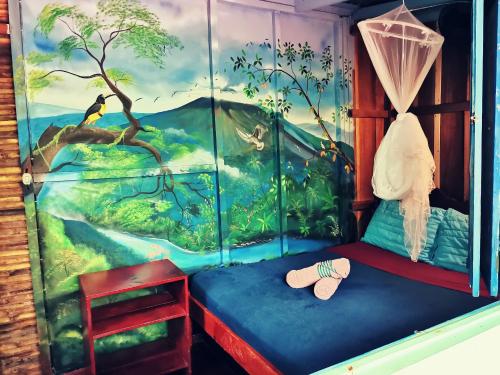 1 dormitorio con un mural de la selva en Hidden Jungle Beach House, en Puerto Viejo
