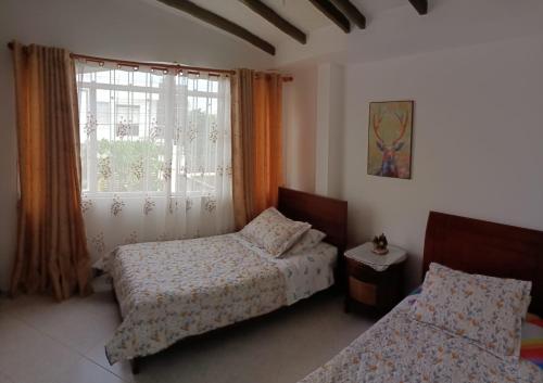 a bedroom with two beds and a window at Hermosa y espaciosa casa familiar en Anapoima in Anapoima