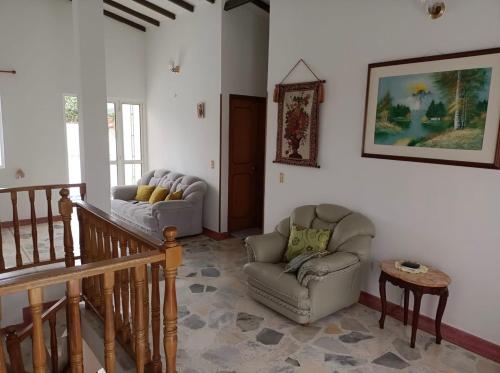a living room with a couch and a chair at Hermosa y espaciosa casa familiar en Anapoima in Anapoima