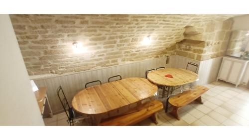 2 tables et bancs en bois dans une pièce dans l'établissement Maison terrasse barbecue à 1 tram de Montpellier et 20 min des plages, à Saint-Jean-de-Védas