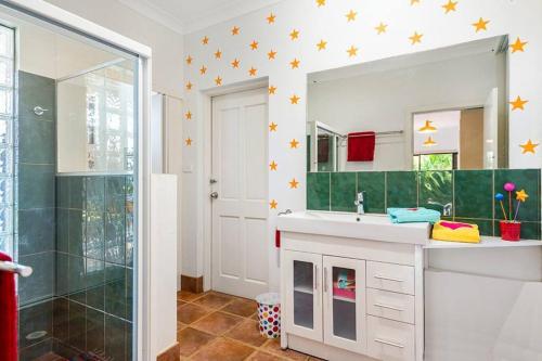 a bathroom with a shower and a sink and a mirror at Donna's Art House in Alstonville