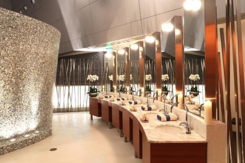 a bathroom with a row of sinks and mirrors at Oryx Airport Hotel -Transit Only in Doha