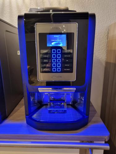 a cell phone in a blue box on a shelf at Hôtel Restaurant Le Relais - Pau Nord in Lons