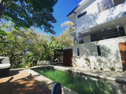 a swimming pool in front of a house at Loft Mágico en Nativa Resort in Tarcoles