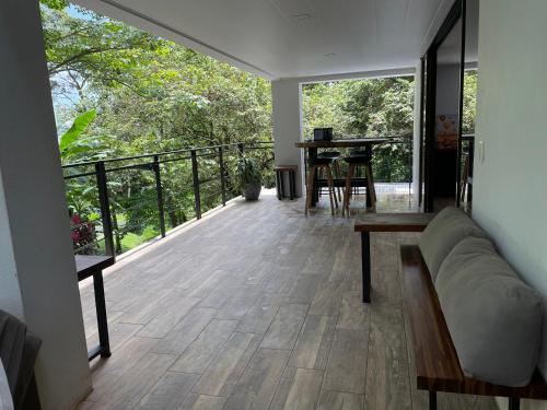a living room with a couch and a table on a balcony at Loft Mágico en Nativa Resort in Tarcoles