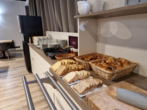 - une cuisine avec du pain et des paniers de pain dans l'établissement Hôtel Restaurant Le Relais - Pau Nord, à Lons