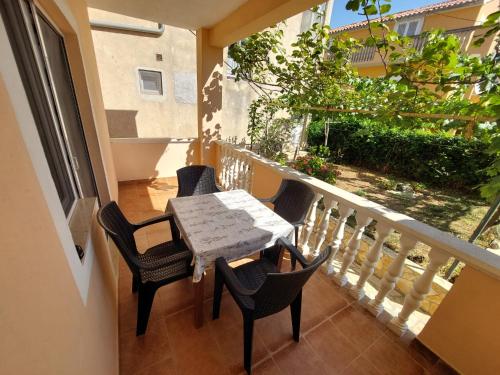 a balcony with a table and chairs on it at Apartments Bor - 20m from the beach in Kraj