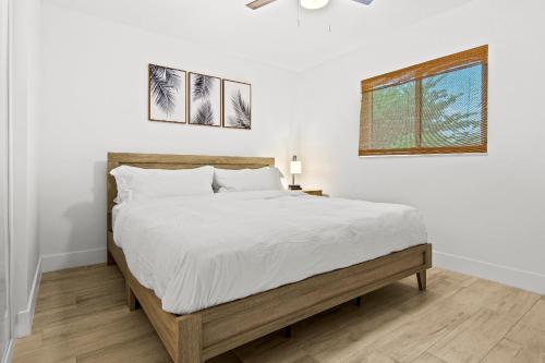 ein weißes Schlafzimmer mit einem großen Bett und einem Fenster in der Unterkunft Your private tropical paradise with heated pool! in Sarasota