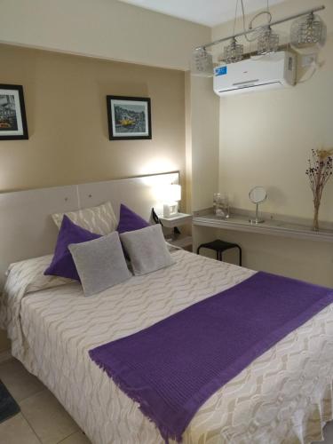 - une chambre avec un grand lit et des oreillers violets dans l'établissement Bello Departamento 2 Habitaciones, Barrio Norte, à San Miguel de Tucumán