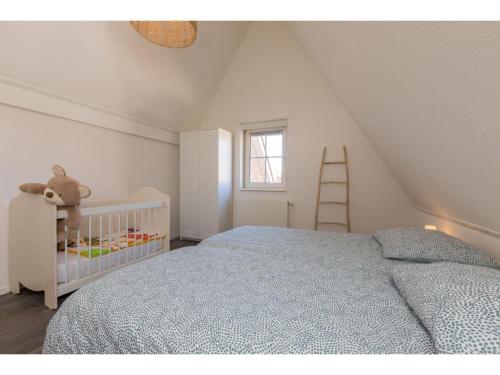 um quarto branco com um berço e uma escada em Quietly located house within walking distance of the beach em Domburg