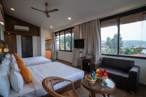 a hotel room with a bed and a couch at Jivanta Mahabaleshwar in Mahabaleshwar
